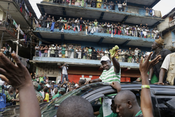 Opposition candidate Julius Maada Bio waves to supporters as his campaign convoy drives through the Kissy neighborhood, en route to his final campaign rally in Freetown, Sierra Leone, Nov. 15.