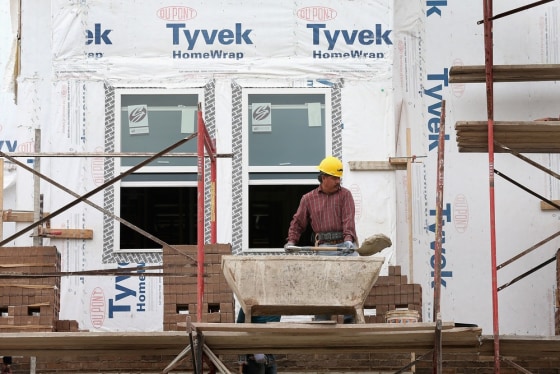 Workers put brick facing on a group of row houses under construction Oct. 17 in Chicago. The housing recovery is building up steam, but lenders need to loosen tight standards for it to accelerate further.