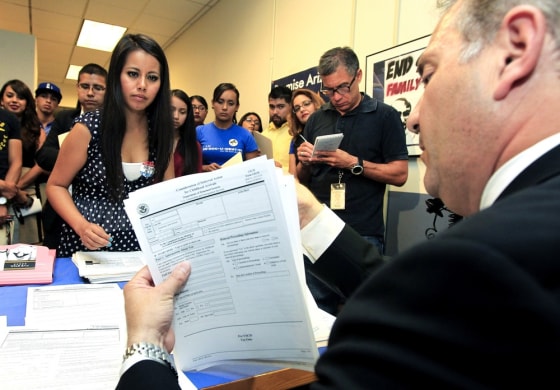 Gaby Perez, left, hands over all her paperwork to get guidance from immigration attorney Jose Penalosa, right, for a new federal program, called Deferred Action, that would help her avoid deportation, August 15. Schools and consulates have been flooded with requests for documents after President Barack Obama announced a new program allowing young illegal immigrants to apply for two-year renewable work permits.