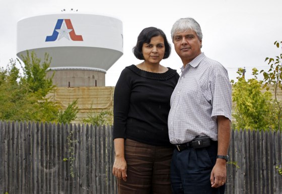 Ranjana Bhandari and her husband, Kaushik De, stand near a Chesapeake Energy gas well in Arlington, Texas, on Sept. 16, 2012.
