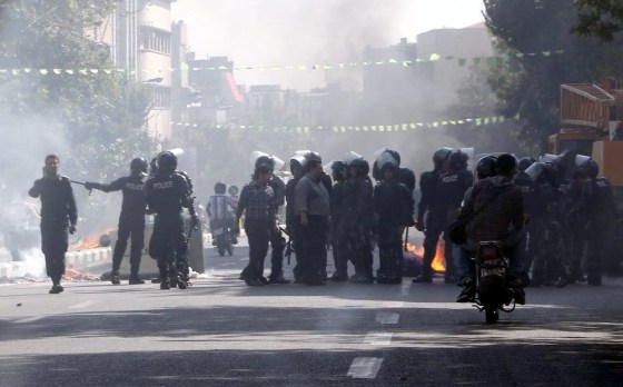 Iranian riot police move in as protesters set garbage on fire near the old main bazaar in the center of Tehran, Iran, on Wednesday.