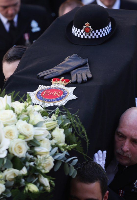 The hat and gloves of police Constable Nicola Hughes lay on top of her coffin as it is carried out of Manchester Cathedral after her funeral service on Oct. 3.