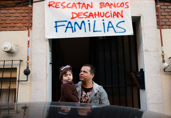 Edward Hernandez Vivas holds his daughter Ariadne outside their apartment before learning that the family's eviction was suspended in Madrid on Oct. 3.