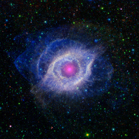 Layers of gas and dust show up clearly in this color-coded composite picture of the Helix Nebula. Ultraviolet wavelengths, as seen by the GALEX probe, are shown in blue. Infrared wavelengths, as seen by NASA's Spitzer Space Telescope, are presented in red, yellow and green. The nebula appears magenta in the center, where the two sets of data overlap. A portion of the extended field beyond the nebula, which was not observed by Spitzer, is from NASA's Wide-field Infrared Survey Explorer.
