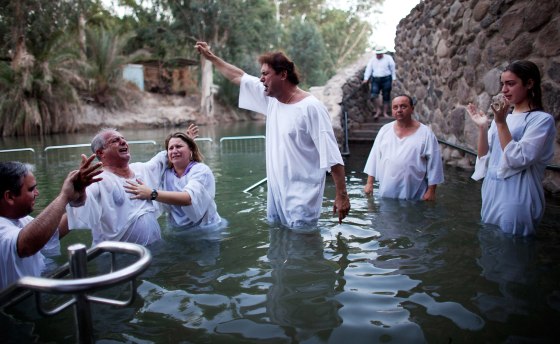 Christian pilgrims take part in a group baptism in the waters of the Jordan River at Yardenit in northern Israel, Oct. 3, 2012.