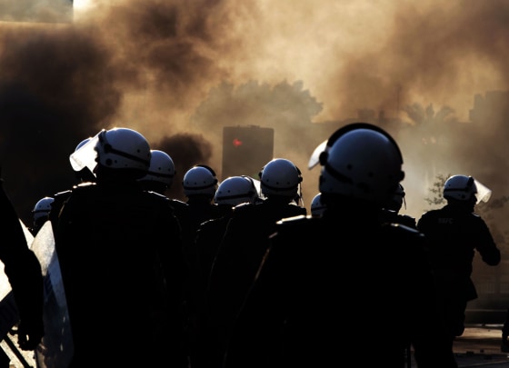Riot police watch for Bahraini anti-government protesters, unseen, near tire fires set by protesters in Sanabis, Bahrain, Oct. 5, 2012. Riot police used water cannons and tear gas on Friday to disperse hundreds of anti-government protesters trying to reach a heavily guarded site that was once the hub of their uprising.