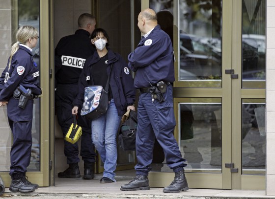 French police officers stand guard at the entrance of a building in Strasbourg, France, Saturday where a suspect was shot dead after firing at police.