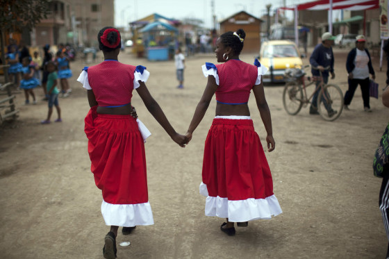 Norma Vargas Portillo, right, and Milagros Gallardo walk hand in hand before performing a traditional Afro-Peruvian dance during festivities in honor of Santa Efigenia in La Quebrada, Peru, Sept. 23, 2012.