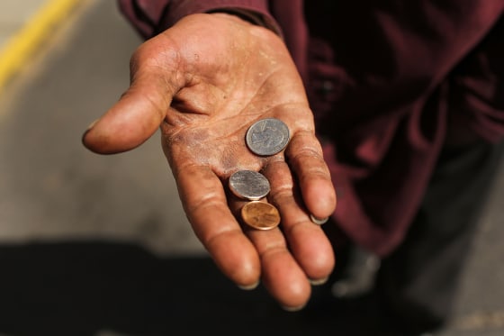 A homeless man panhandles on a street in Camden, N.J., Oct. 11.