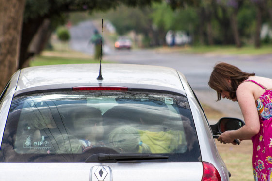 Melanie Minnie, a teacher at the Rietfontein nursery school, stands beside her car after being fined by the Tshwane Metro Police for transporting 19 children in the vehicle on October 11, 2012 in Pretoria, South Africa.