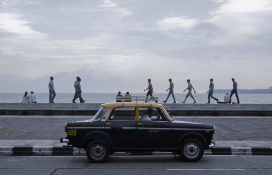 A driver waits for customers on Marine Drive in Mumbai on October 2, 2012.