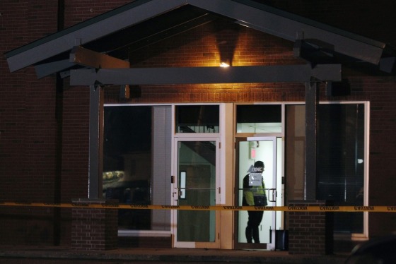 A Framingham police officer (in doorway) keeps watch as federal agents search the New England Compounding Center company in Framingham, Massachusetts October 16, 2012.