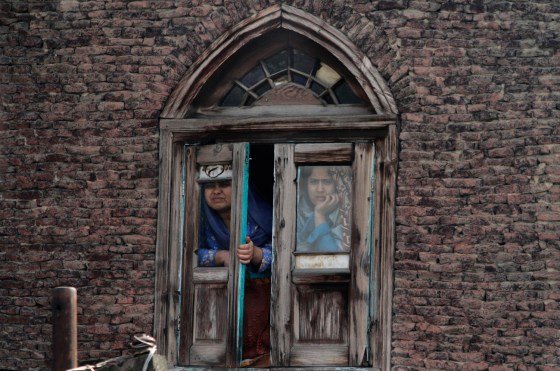 Kashmiri Muslim women look out from a window as residents protest in Srinagar, India, on Oct. 17. Dozens of residents blocked traffic and protested against the government decision to hike electricity bills and for capping the number of subsidized cooking gas cylinders at six a year.