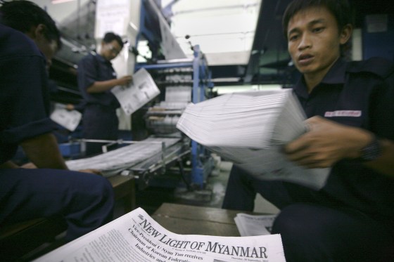 Employees get freshly printed copies of the New Light of Myanmar at the newspaper's office in Naypyitaw, Sept. 19, 2012. Established in 1993, the state-run New Light of Myanmar is the country's only English-language daily newspaper. It will soon face competition from private publishers and is undergoing a redesign.