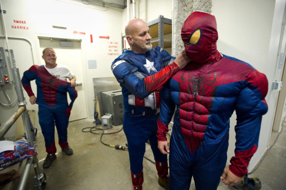 Window washers with American National Skyline, Jordan Emerson, left, Steve Oszaniec, center, and Danny Oszaniec don superhero costumes before rappelling down the outside of Le Bonheur Children's Hospital.