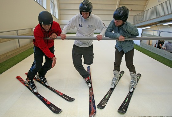 Cyclist Mark Cavendish watches as skier Graham Bell (left) shows amputee Andy Barlow how to ski on the new Skiplex slope that has been installed at the new Help for Heroes' Tedworth House rehabilitation center.