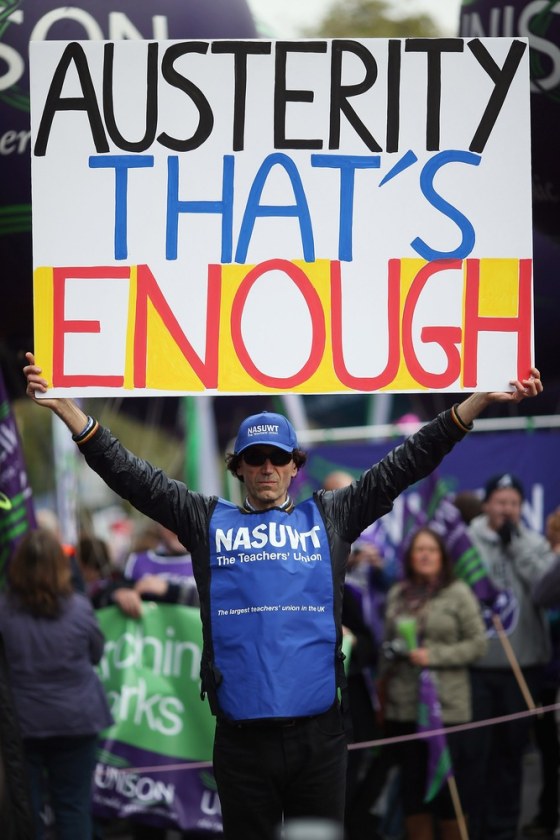 A man holds up a banner reading 'Austerity - That's Enough' as a march to protest the government's austerity measures prepares to set off from the Embankment in London on Friday.