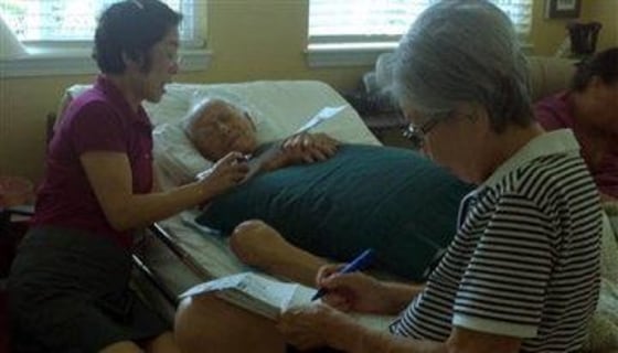 In this Oct. 17, 2012 photo provided by Irene Tanabe, 93-year-old World War II veteran Frank Tanabe, center, gets help from his daughter Barbara Tanabe, left, to fill out his absentee ballot in Honolulu while his wife Setsuko Tanabe sits in the foreground.