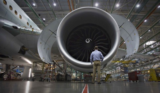 A worker stands in front of an engine on the Boeing 777 at an assembly operation in Everett, Wash., Oct. 18, 2012. Boeing is ramping up all production to produce more jets, more quickly than ever before. It's a race to turn a record backlog of more than 4,000 orders into revenue and profit, which airlines and investors will be watching when the company posts third-quarter results on Oct. 24.