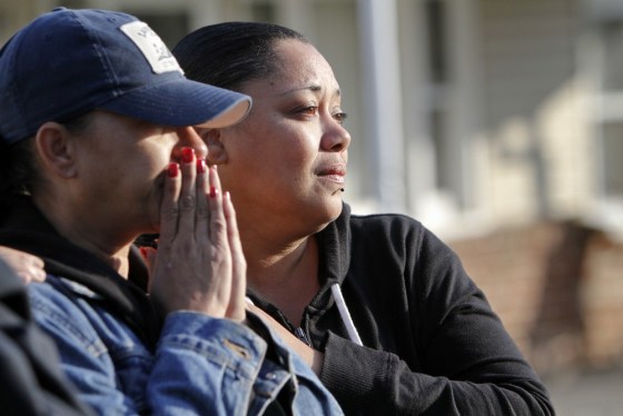 Gina Bateman, left, and her sister Carmen Bateman watch as investigators gather at a house on Clayton Avenue in Clayton N.J. on Oct. 23, after the discovery of a girl's body in a home's recycling bin.