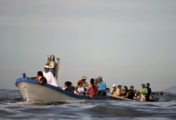 Fishermen sail a boat with an image of Saint Raphael the Archangel during a procession, at the port of La Libertad, south of San Salvador, on Oct. 23.
