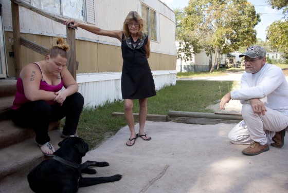 Kathleen Hucks, 57, center, shown with her daughter Nicole, 23, and husband James, 64, outside the family's mobile home in Augusta, Ga., filed suit last week against a for-profit probation company alleging it violated her constitutional right to due process.