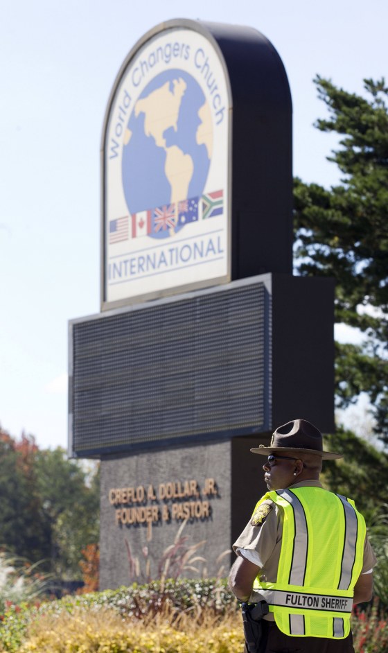 A Fulton County sheriff's deputy stands guard Wednesday outside the World Changers International church near College Park, Ga., after a fatal shooting inside.