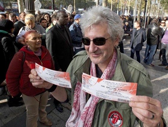 A fan shows off his Rolling Stones tickets, purchased for a small Paris show.