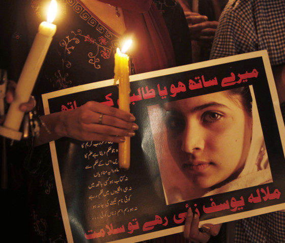 Participants hold a poster of Malala Yousufzai at a vigil for the shooting victim on Oct. 11 in Islamabad, Pakistan.