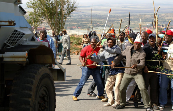 Striking miners react as they make way for a security vehicle at the AngloGold Ashanti mine in Carletonville, northwest of Johannesburg Oct. 25, 2012.
