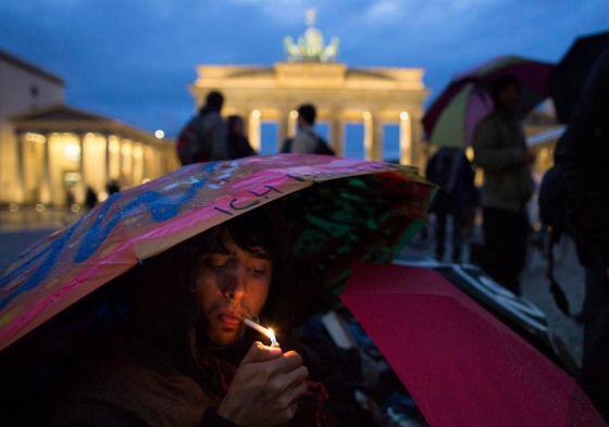 Afghan refugee Maiwand smokes a cigarette as he sits under an umbrella in front of Brandenburg Gate during a hunger strike in Berlin on Oct. 25.