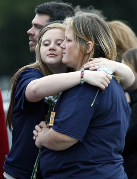Mourners hug during an interment service at the Cedar Green Cemetery in Clayton, N.J., on Saturday.
