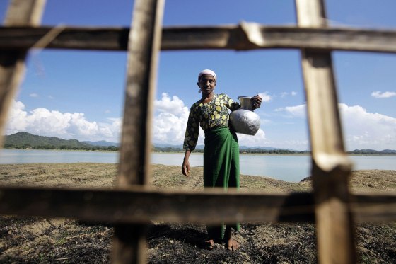 A Muslim woman collects water outside her village, which was partially burnt in recent violence, in Mrauk Oo, Myanmar, Oct. 29, 2012.