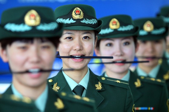 Chinese customs officers get a lesson in perfecting their smile, by holding chopsticks between their teeth.
