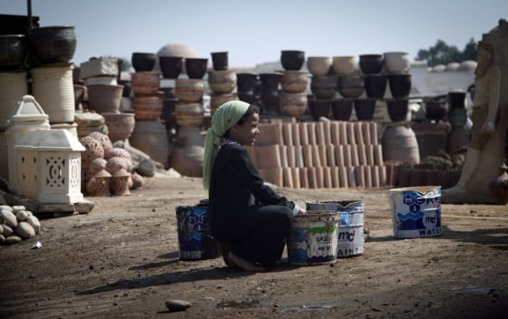 An Egyptian girl fills water containers at a pottery workshop in old Cairo. Photo taken on Oct. 18.