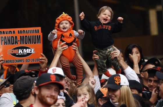 Cousins Reagan Hagerstrand and Ryan Magnani react as they are lifted above the crowd during the Giants' World Series winners parade along Market Street in San Francisco on Oct. 31.