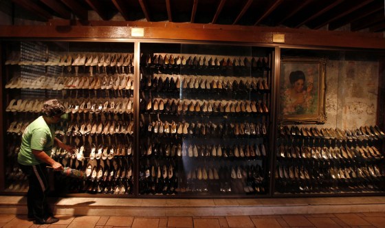 A volunteer cleans shoes of former Philippine First Lady Imelda Marcos on display on Wednesday.