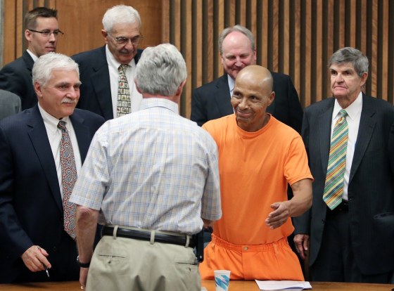 Lewis Taylor shakes hands with his first attorney from 1972, Howard Kashman, as his current defense team surrounds him after a hearing in Pima County Superior Court in Tucson, Ariz., on Tuesday April 2.