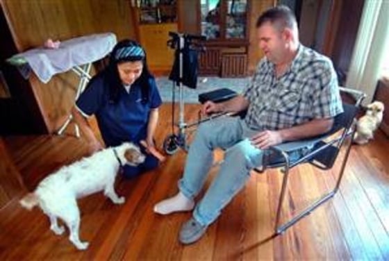 Jerry and Rosie Douthette play with their terrier, Kiko, at their home in Rockford, Mich., on Sunday.