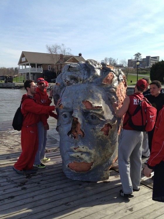Members of the Marist college crew team stand by a giant foam head found floating in the Hudson River in Poughkeepsie, N.Y., on Monday, April 22.