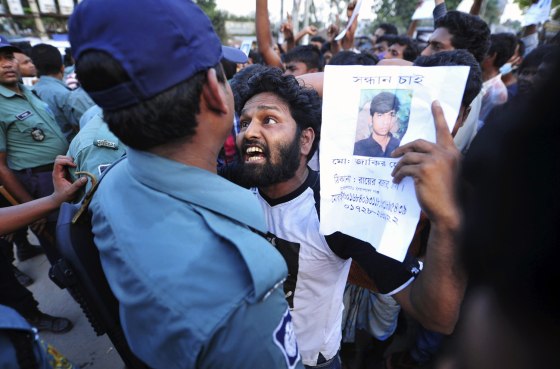 A man argues with a member of the police April 29 as he holds a picture of a missing garment worker during a protest demanding capital punishment for those responsible for the collapse of the Rana Plaza building in Savar, outside Dhaka, Bangladesh.