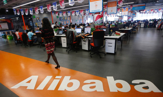 An employee walks past a logo of Alibaba Group at its headquarters on the outskirts of Hangzhou, Zhejiang province, in this May 17, 2010 file photo. C...