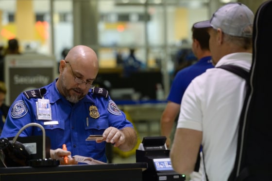 Transportation Security Agency officer verifies a passenger's identification and travel documents at a passenger screening area at Hartsfield-Jackson Atlanta International Airport in Atlanta, Ga., on Aug 19.