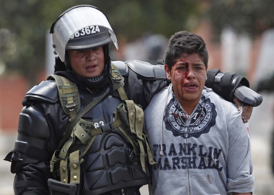 A riot police officer detains a bleeding protester in Ubate on Aug. 26.