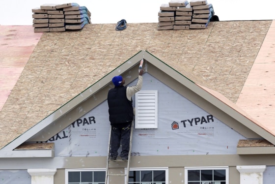 In this Monday, Nov. 11, 2013 photo, a worker caulks the peak of a new condominium complex under construction in Pepper Pike, Ohio.