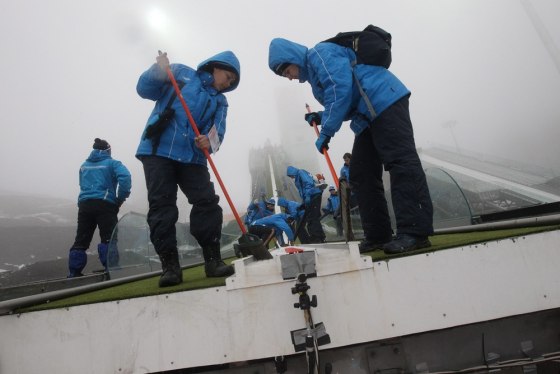 Volunteers prepare a ski jumping hill in Sochi, Russia, on Feb. 1.