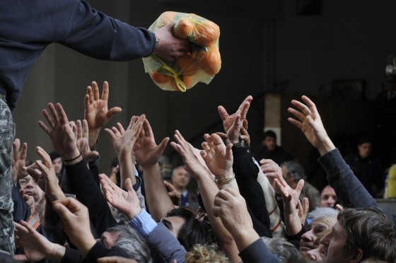 People reach out for a bag of oranges during a free distribution of fruit and vegetables by Greek farmers outside the Agriculture Ministry in Athens, part of a farmers' protest against high production costs on Feb. 6, 2013.