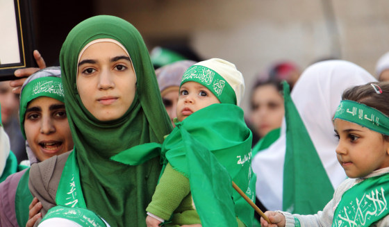 Palestinians participate in a Hamas rally as part of celebrations marking the 25th anniversary of the Islamist movement's founding in Qalqilya City in the West Bank on Dec. 15.