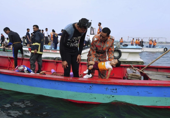 Rescue workers carry the body of a victim after a ferry sank in Munshiganj on Feb. 8, 2013.