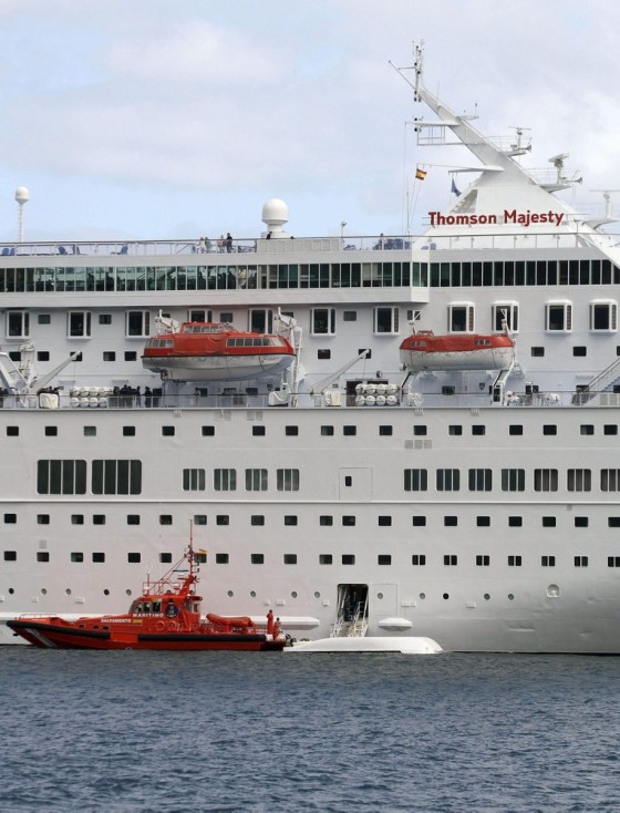 A rescue vessel (bottom L) is seen next to the overturned lifeboat (bottom R) of the 'Thomson Majesty' cruise ship (behind) at the pier where 'Thomson Majesty' cruise ship is docked at Santa Cruz de la Palma, Canary Islands, Spain on Feb. 10.